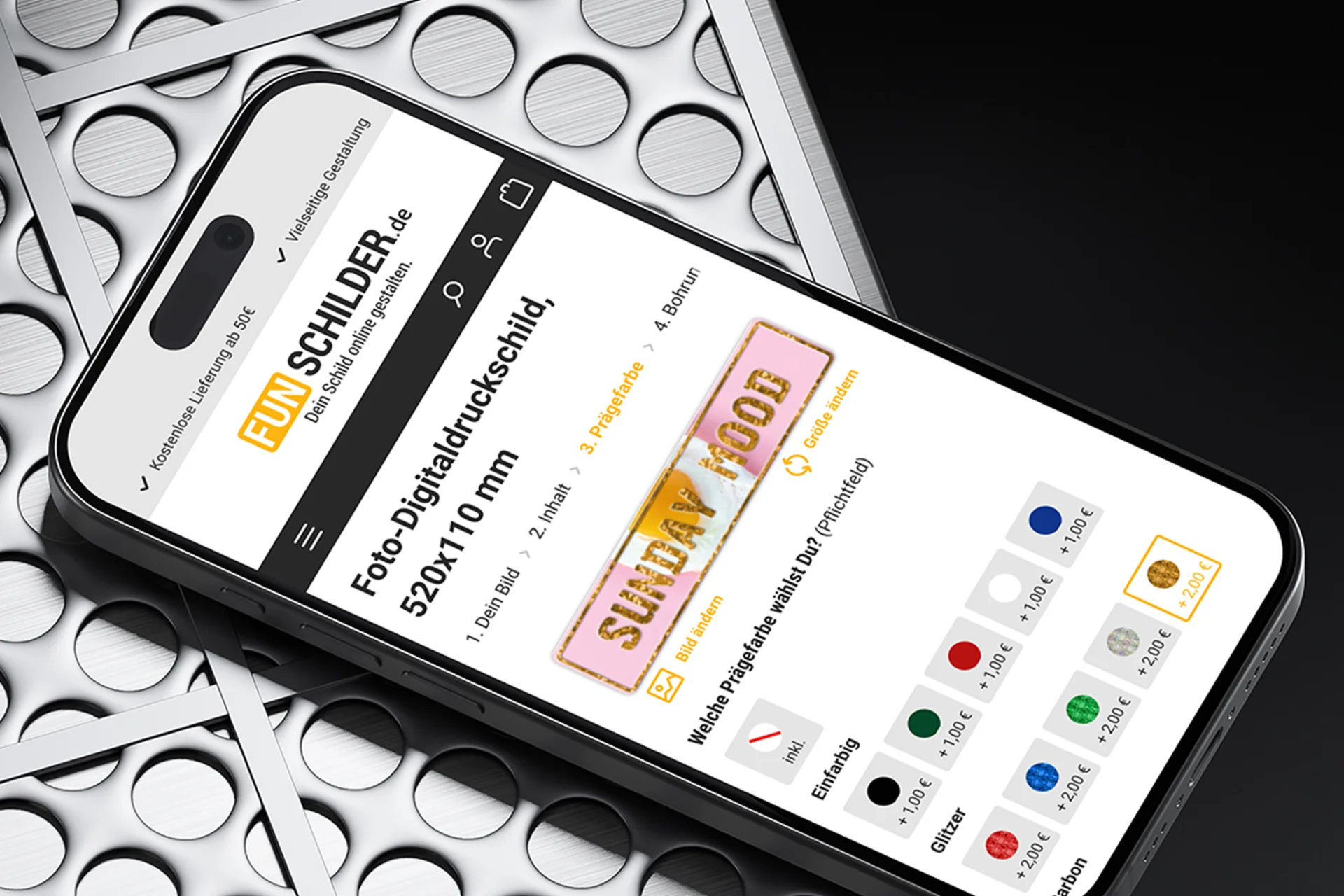 Smartphone auf metallischem Hintergrund mit geöffnetem Funschilder.de Onlineshop und Funschild-Konfigurator