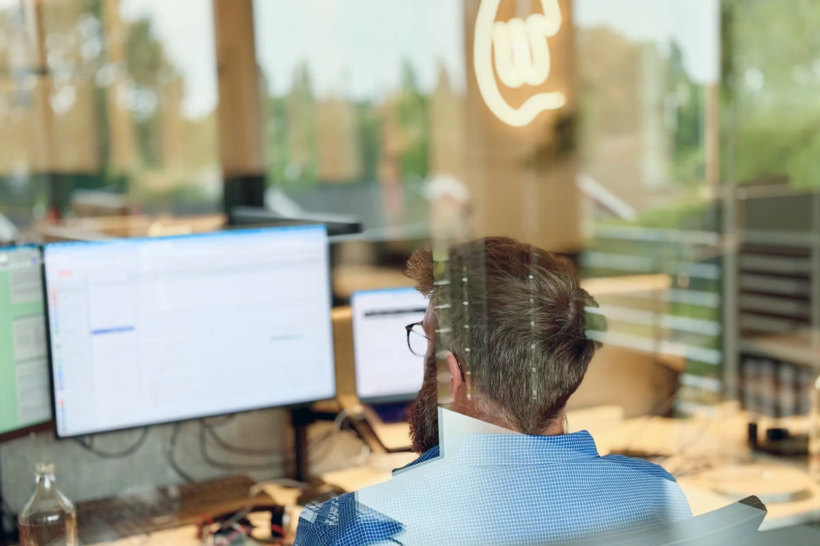 Person arbeitet auf mehreren Bildschirmen